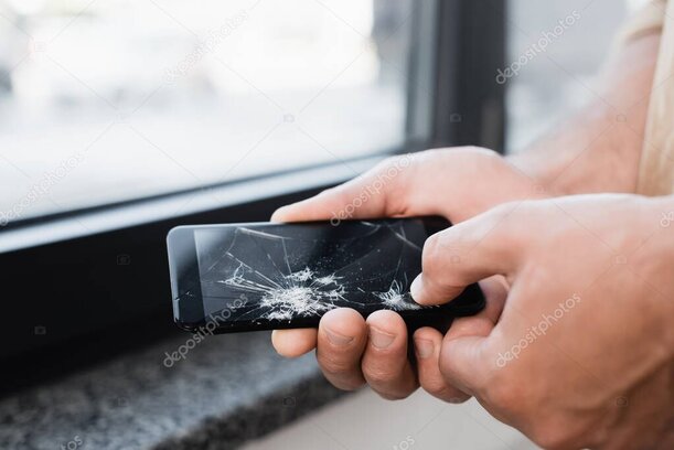 Smartphone avec écran cassé tenu dans une main